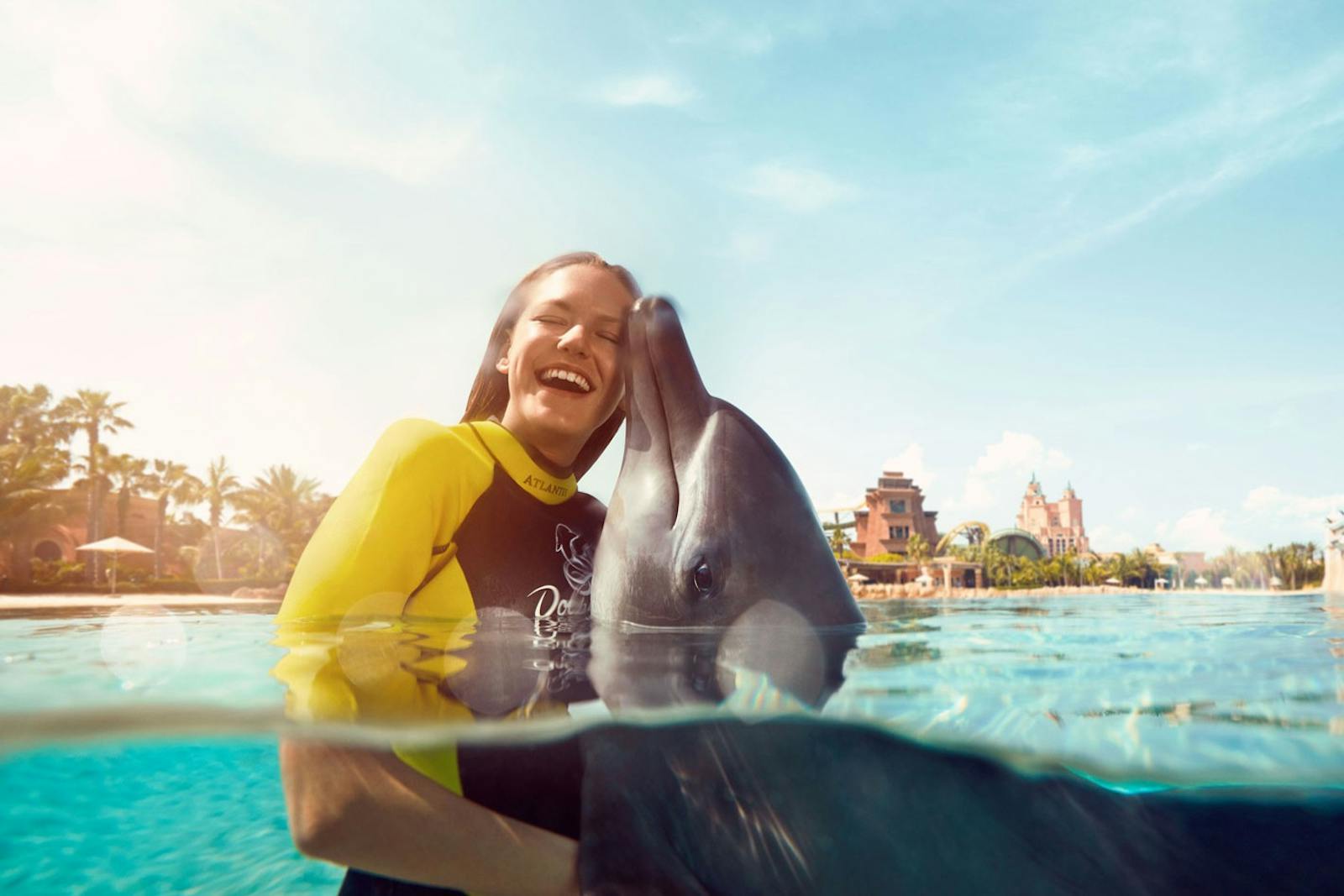 Mujer riendo con un delfín en Aquaventure World